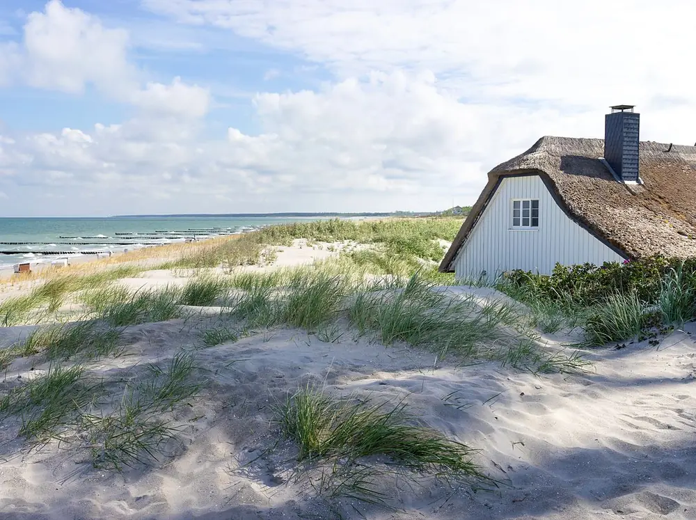 Rohrdachhaus hinter den Dünen am Meer