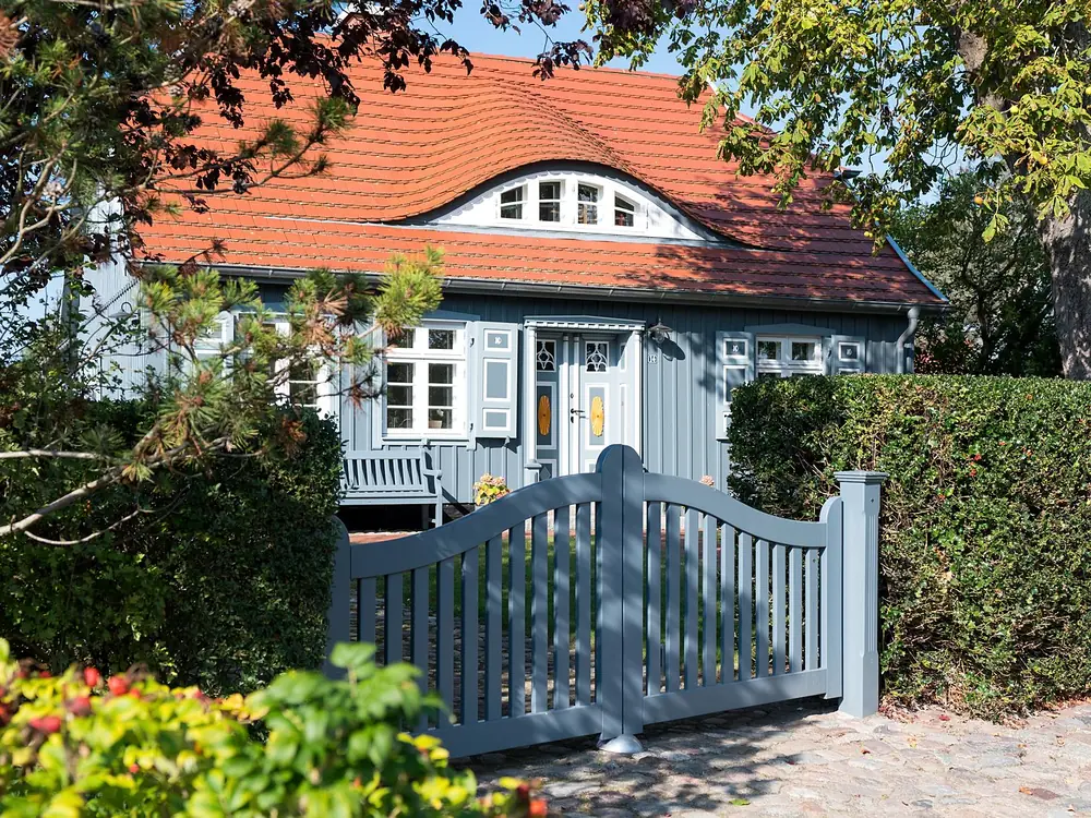 Haus mit blauen Fensterläden und Holztor