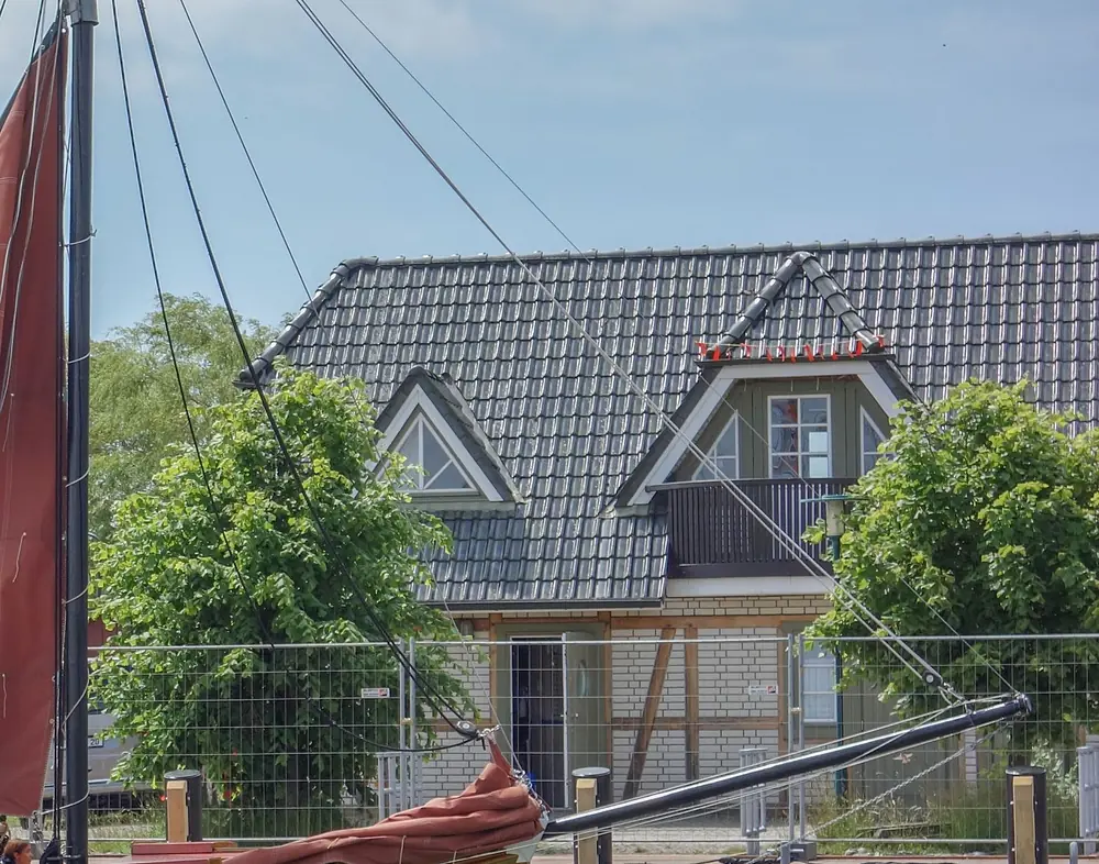 Haus am Hafen hinter dem Mast eines Zeesboots