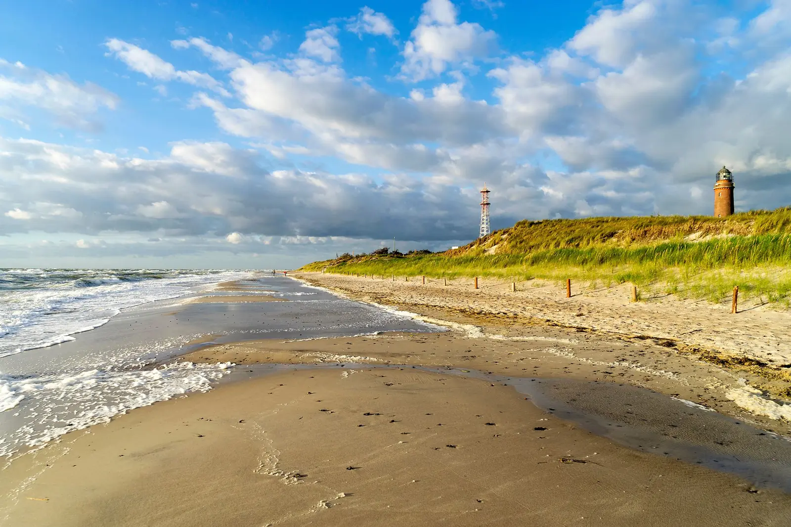 Strand am Darßer Ort mit dem Leuchtturm hinter den Dünen