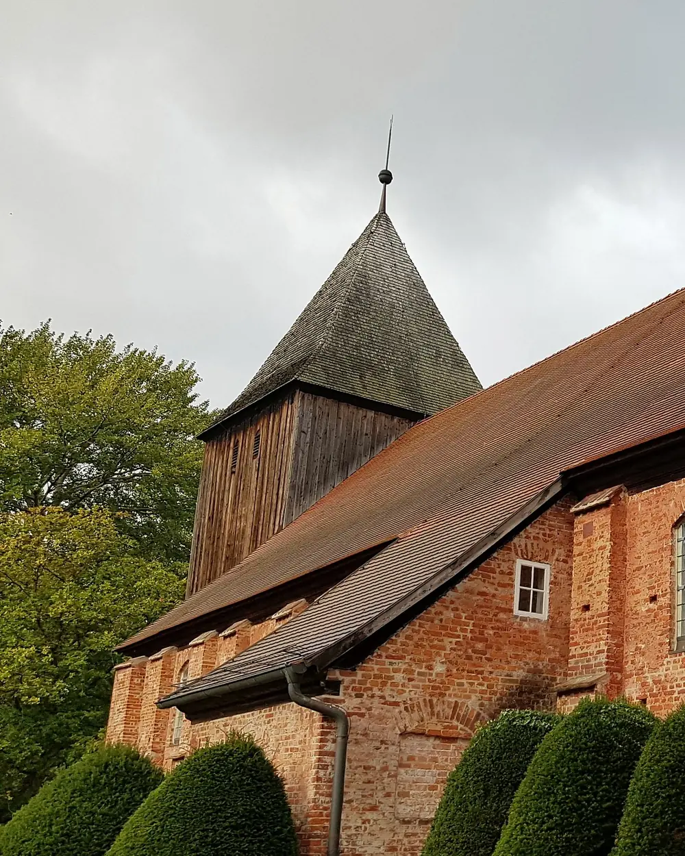 Hölzerner Kirchturm über dem Backsteinschiff